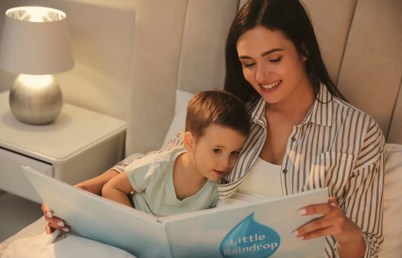 Une femme lisant un livre à un petit garçons