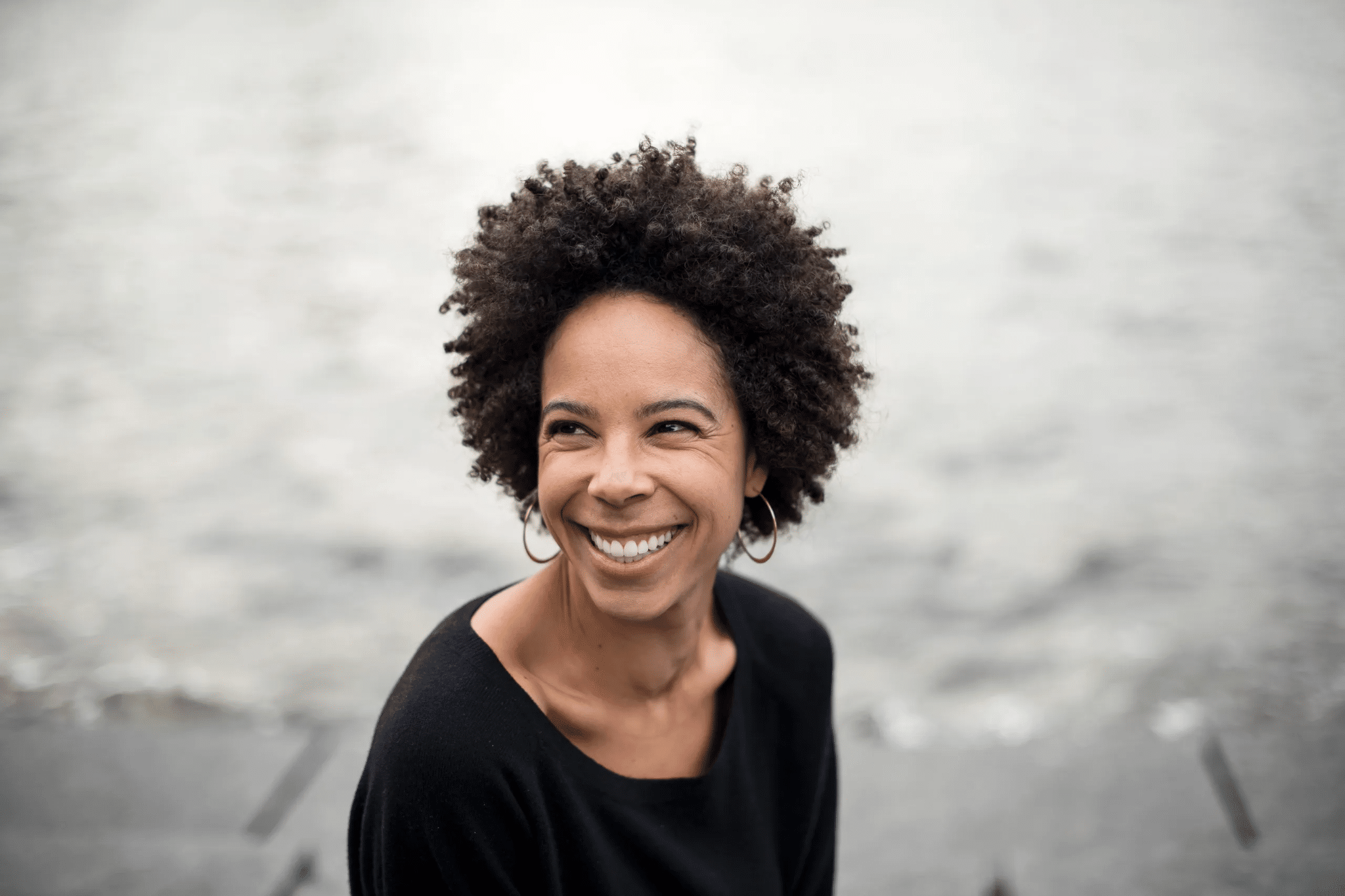 Ayana Elizabeth Johnson, biologiste marine et spécialiste des politiques climatiques, souriante en extérieur