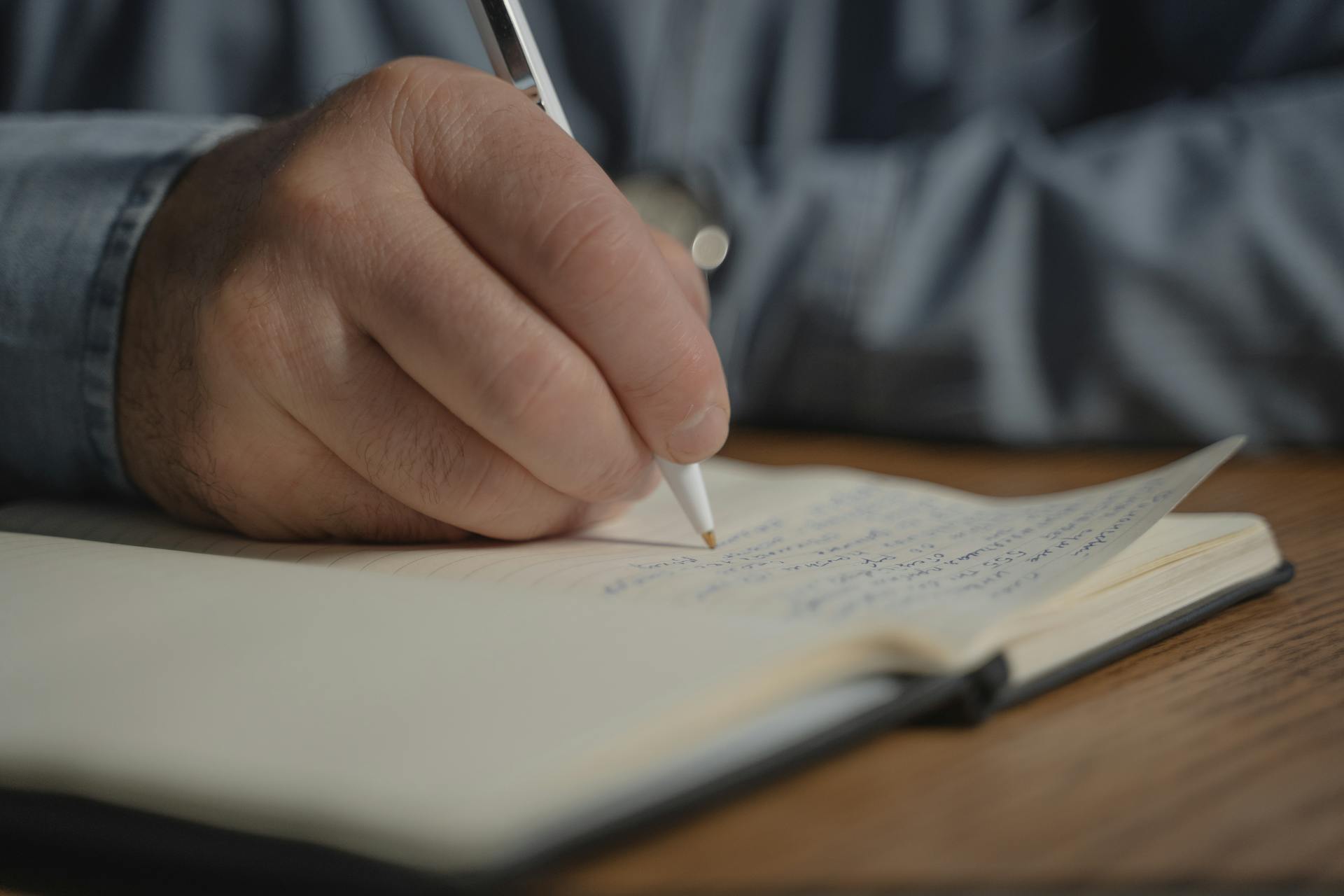 Main écrivant dans un carnet illustrant l’analyse de l’écriture dans la schizophrénie et les troubles du langage