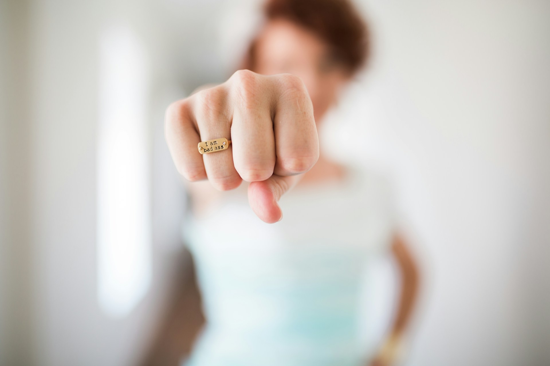 Femme levant le poing avec une bague « I am a badass », symbole de confiance et d’affirmation des femmes