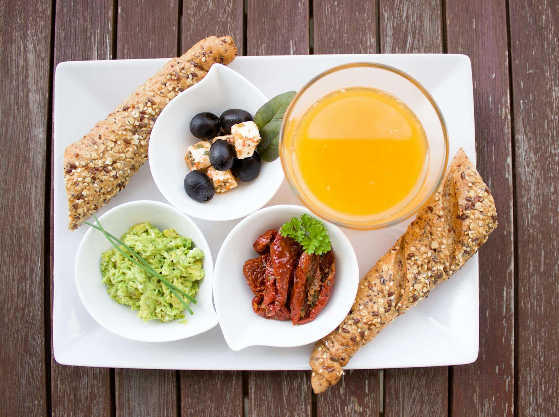 Petit-déjeuner sain après Ramadan avec pain complet, olives, fromage, avocat et jus d’orange