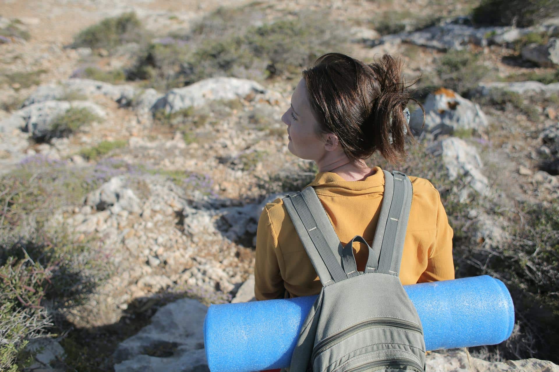 Femme en randonnée en pleine nature avec sac à dos, illustrant le sport idéal après 40 ans