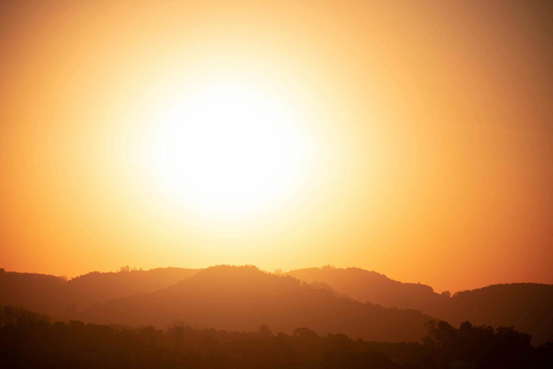 Soleil intense au-dessus d’un paysage illustrant la hausse des températures liée au réchauffement climatique
