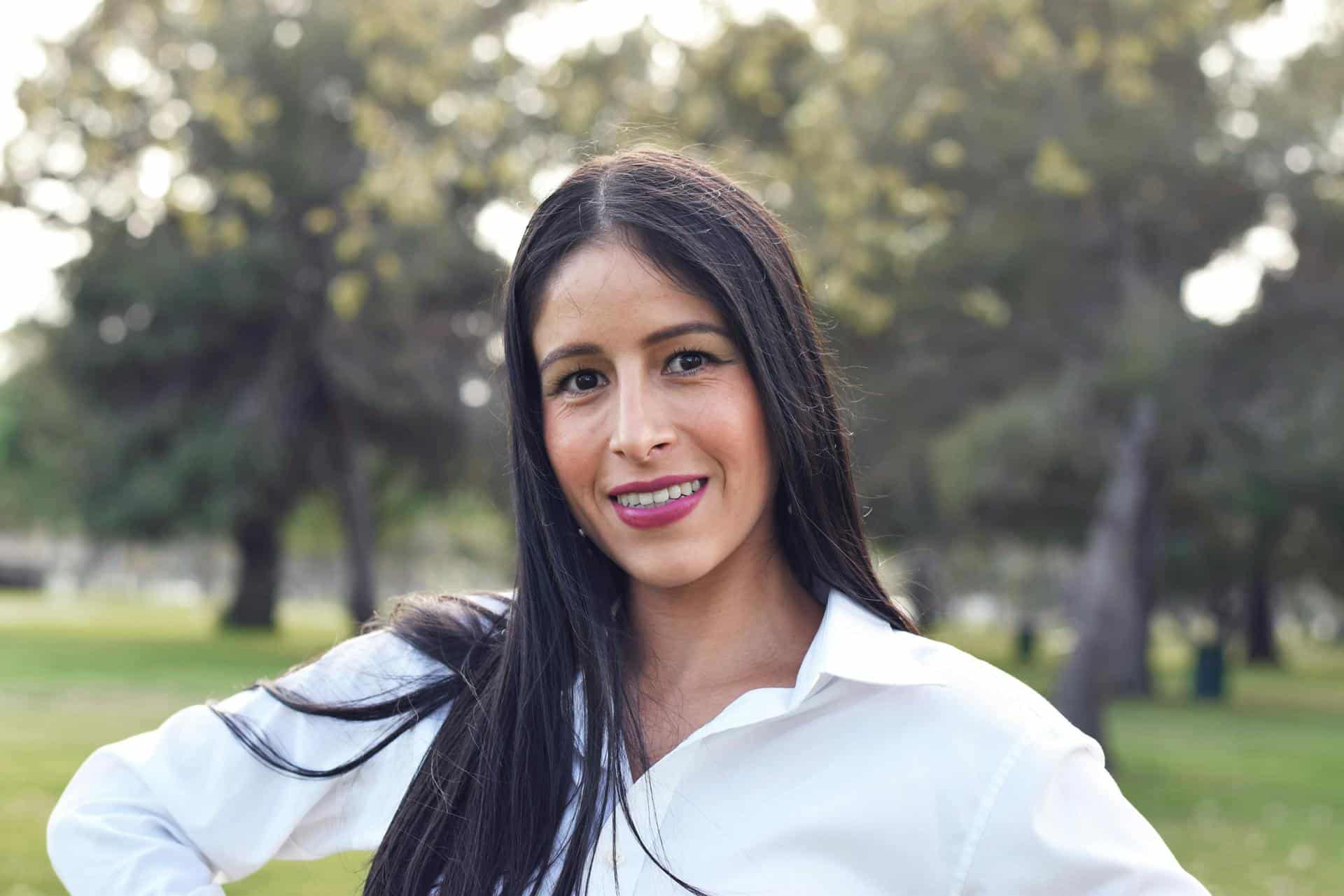 Femme souriante en extérieur illustrant les changements hormonaux à l’âge adulte appelés seconde puberté