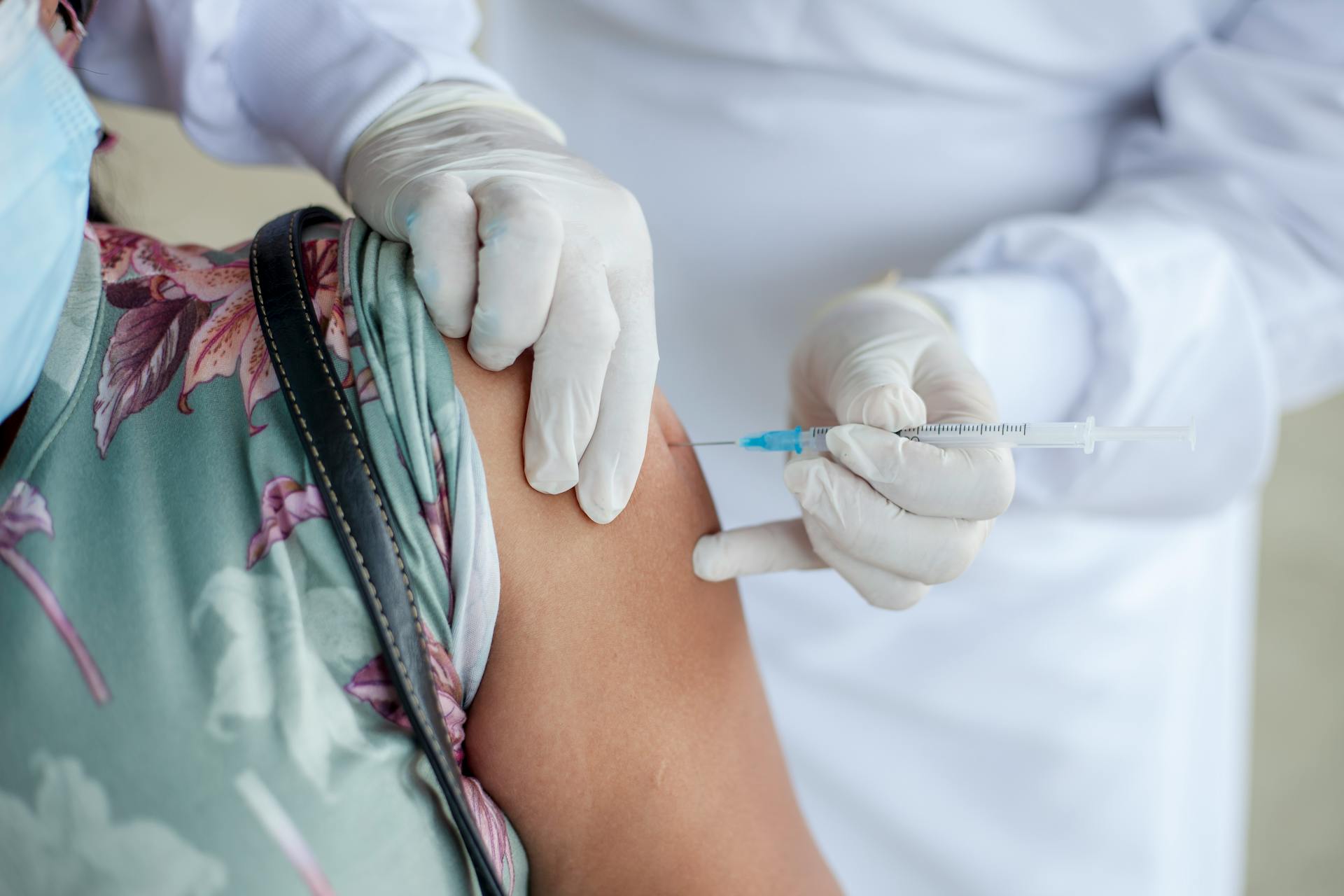 Professionnel de santé administrant un vaccin dans le bras d’une patiente, illustrant les campagnes de vaccination