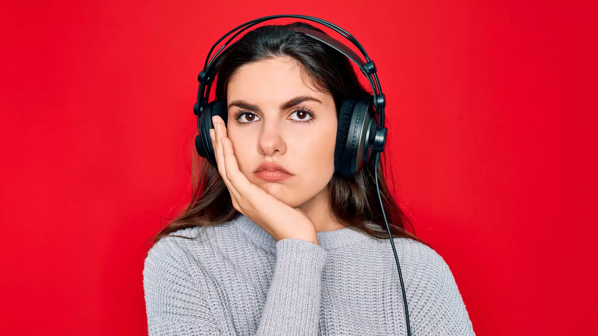 Femme surprise en écoutant sa voix avec un casque audio, illustrant le décalage entre voix réelle et perçue