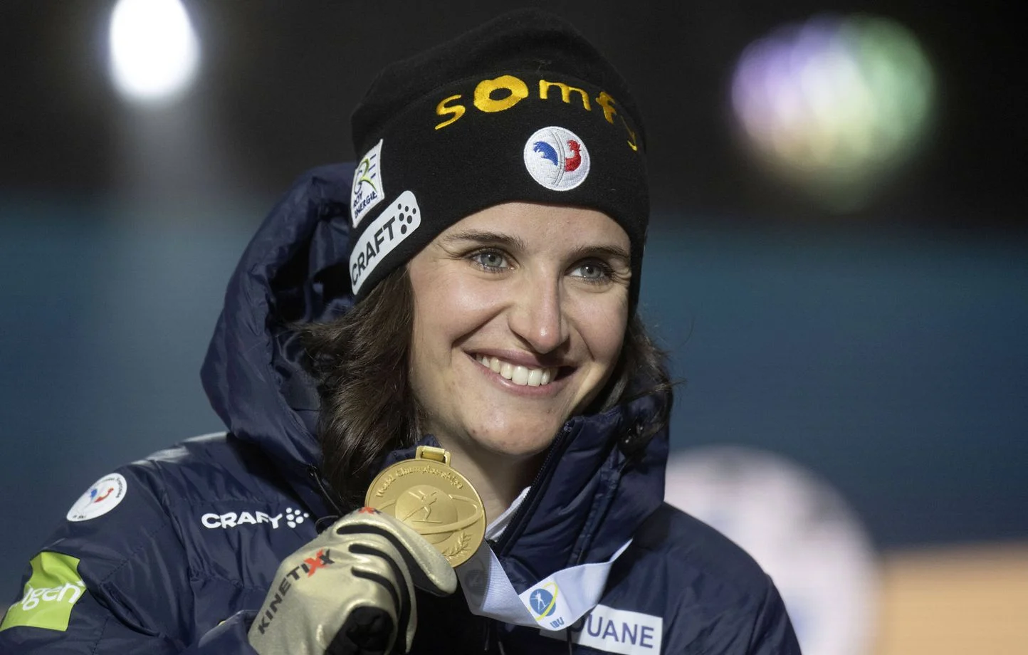 Julia Simon en biathlon avec sa médaille d’or, évoquant l’impact des règles sur la performance dans le sport féminin