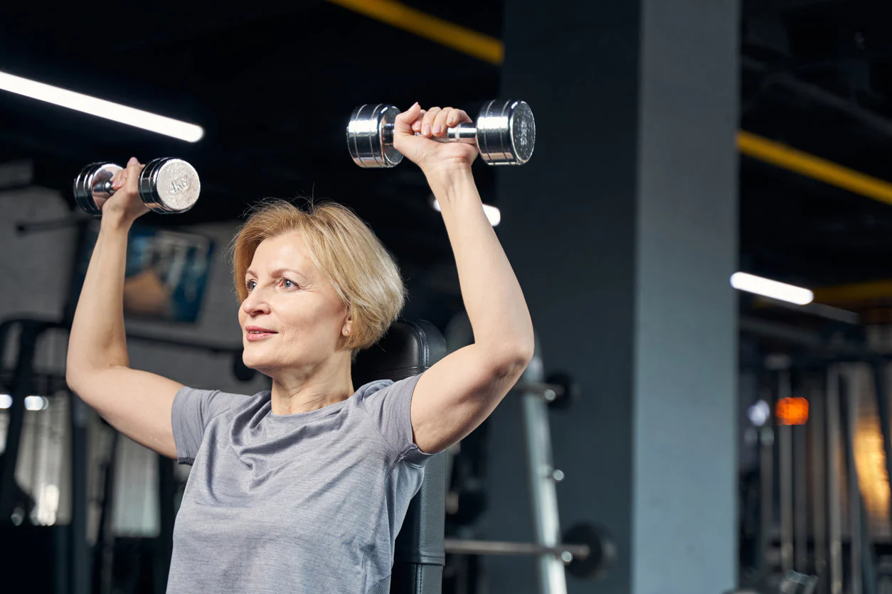 Femme faisant de la musculation avec des haltères pour renforcer sa santé pendant la ménopause