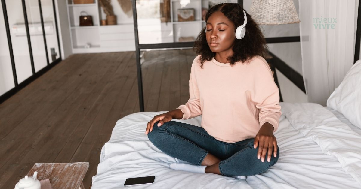 Femme meditant sur une application de méditation gratuite sur son lit