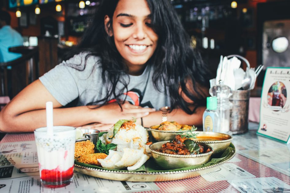 Une femme avec une assiette équilibrée et colorée à base de légumes et de céréales complètes pour une bonne alimentation